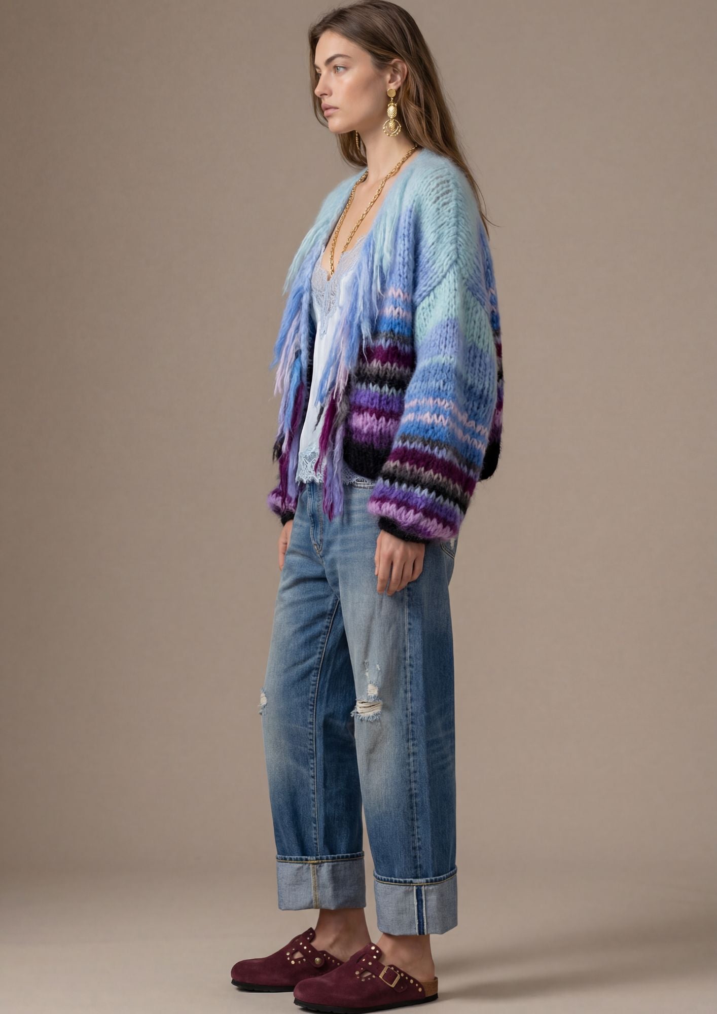 Woman wearing a colorful sweater and jeans on a beige background