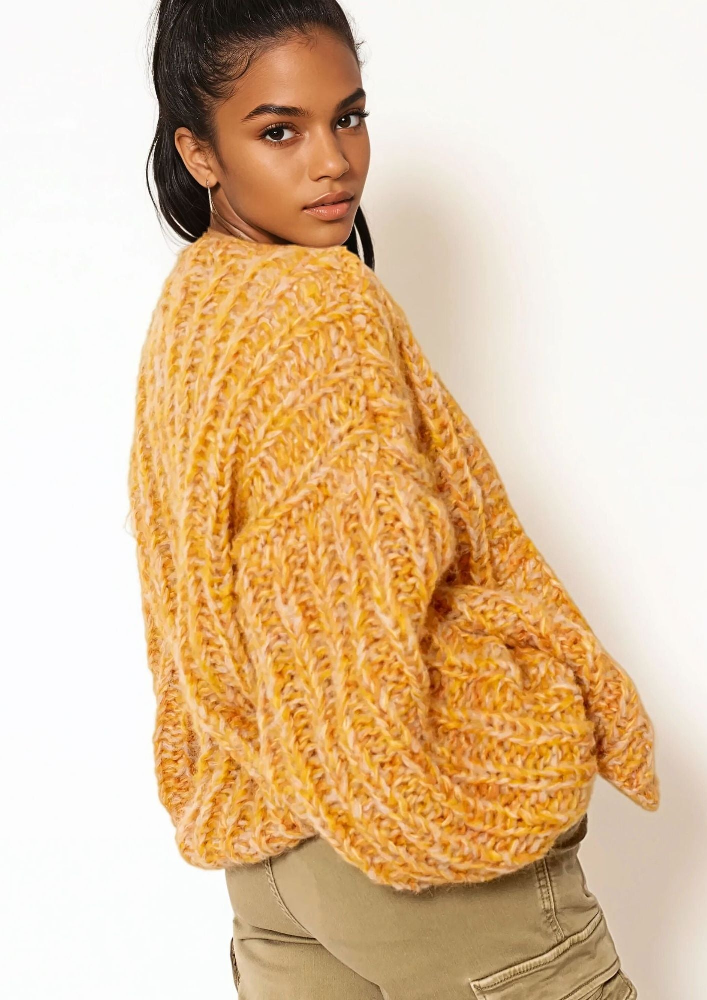 Girl with dark hair in white t shirt and light orange  handknitted oversized luxury mohair cardigan