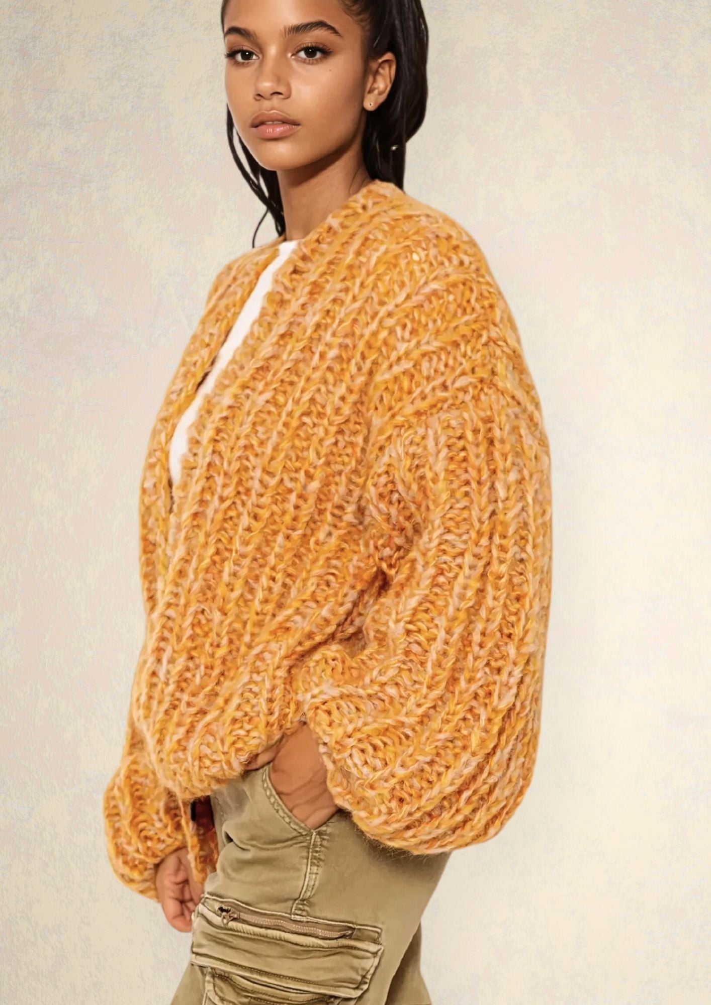 Girl with dark hair in white t shirt and light orange  handknitted oversized luxury mohair cardigan