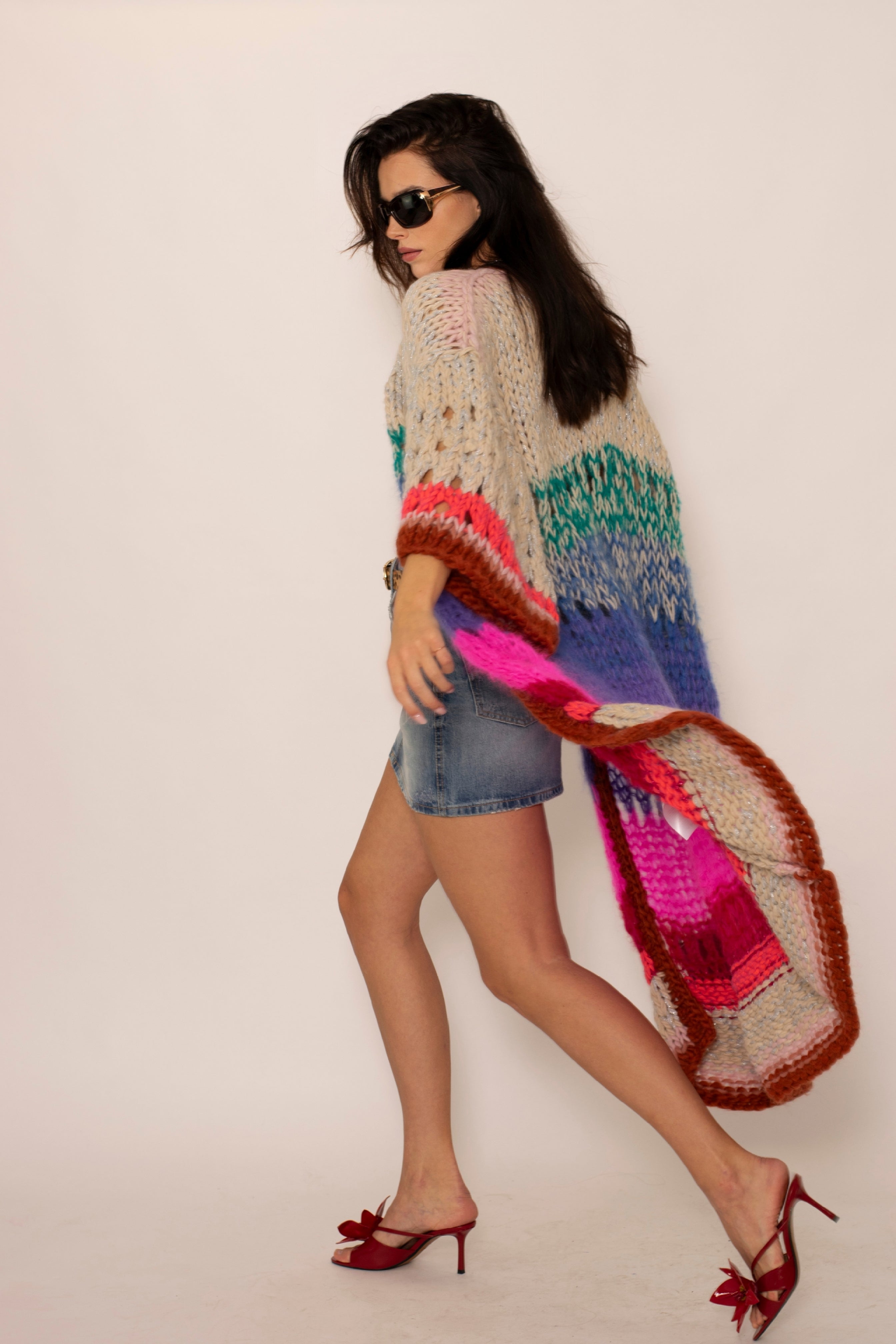 Walking woman with sunglasses and an oversized handknitted long cardigan