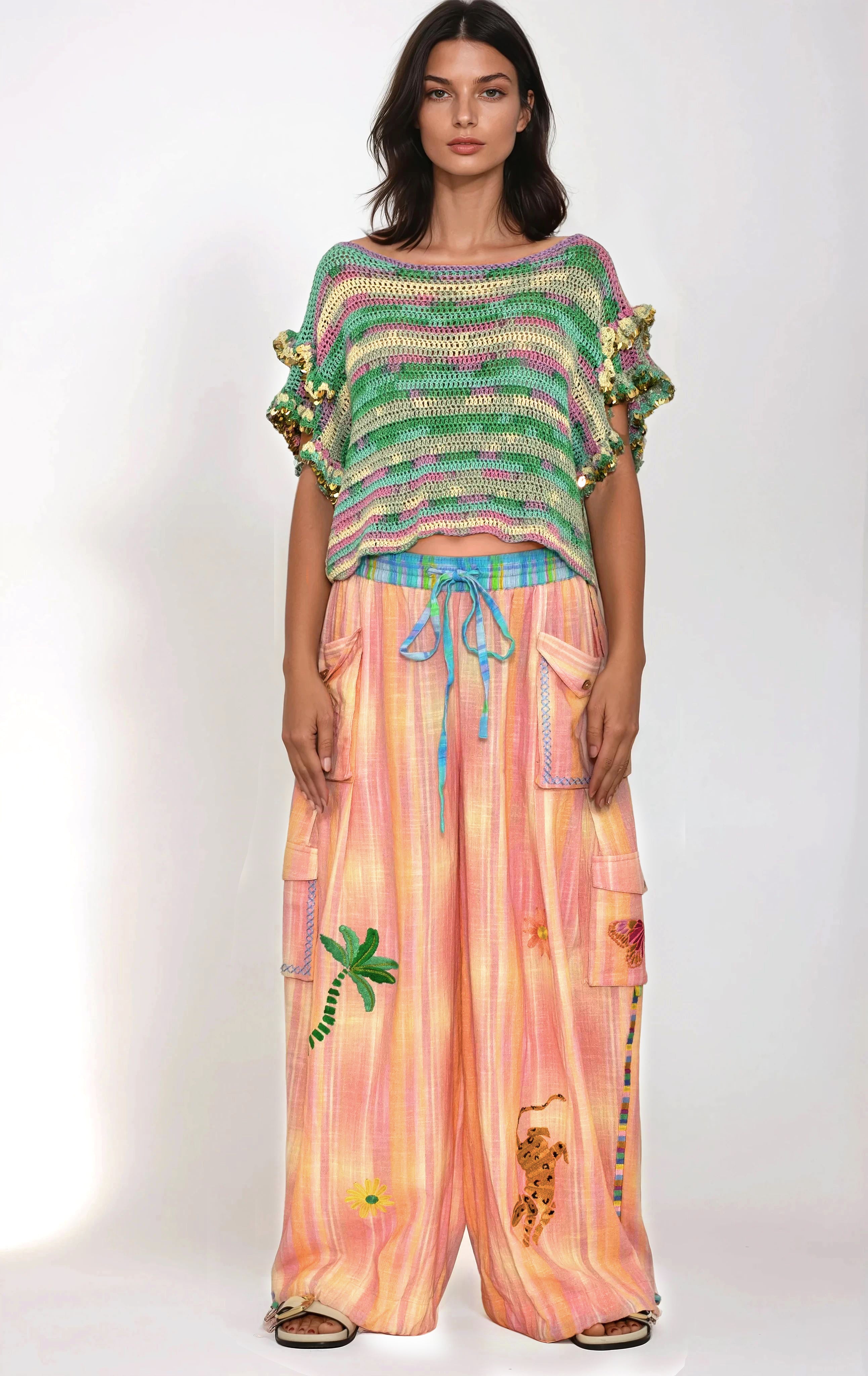 Woman wearing a colorful striped top and pink pants with animal prints on a white background
