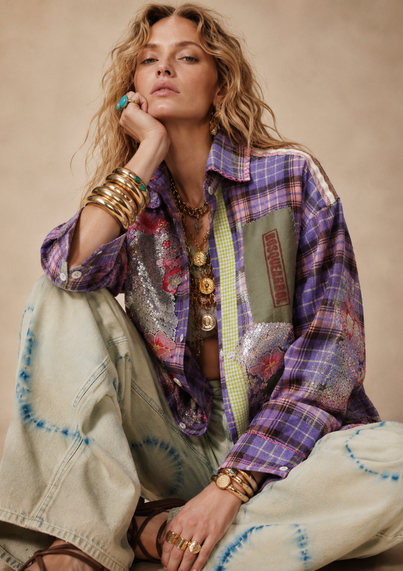 Woman wearing a colorful patchwork jacket with a neutral background