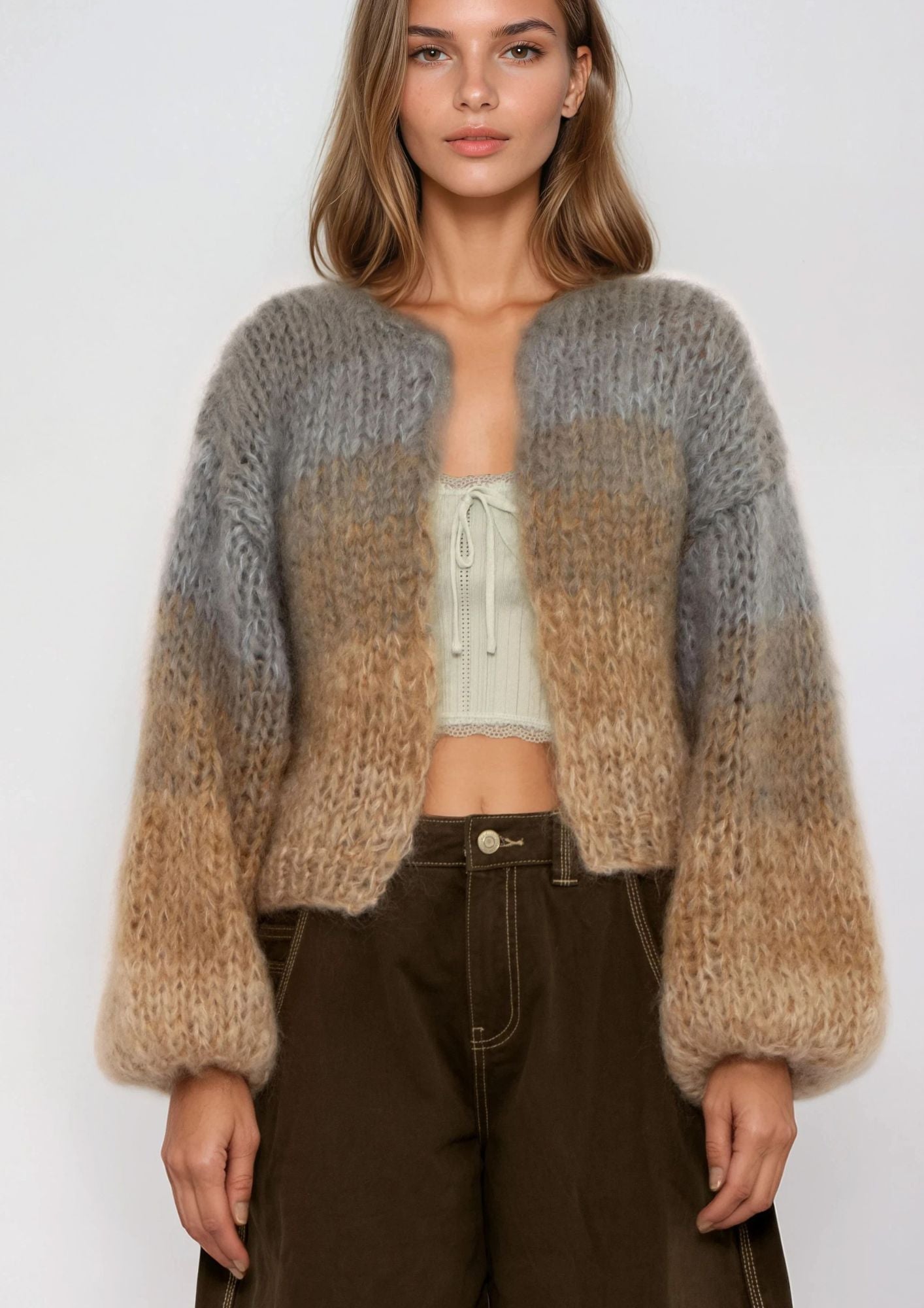 Woman wearing a two-tone knit cardigan with a plain background