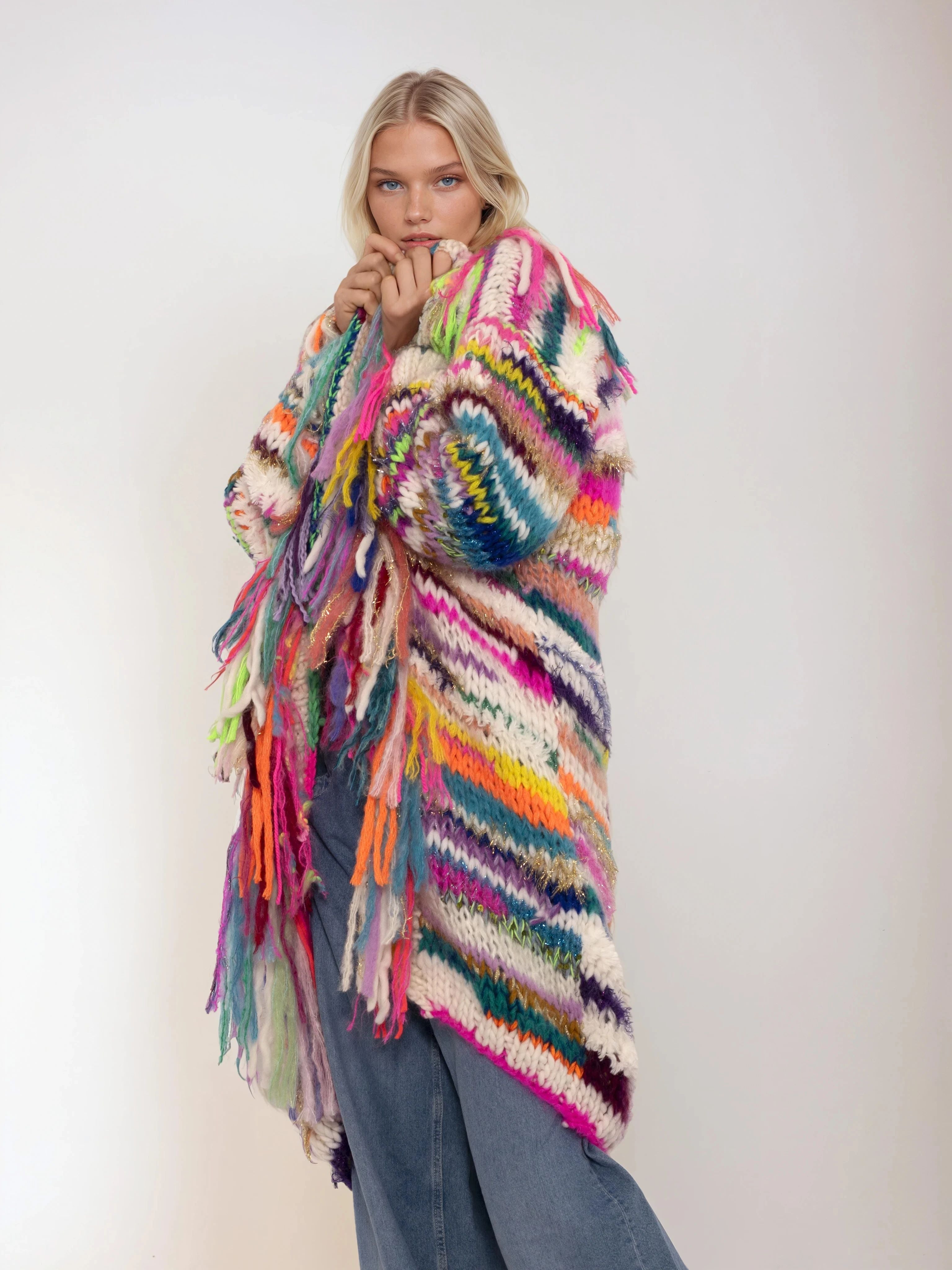 Woman wearing a colorful handknitted cardigan on a white background