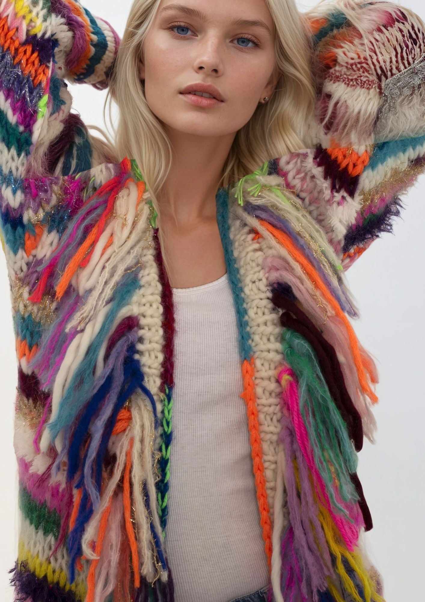 Woman wearing a colorful, patterned handknitted coat with a white background