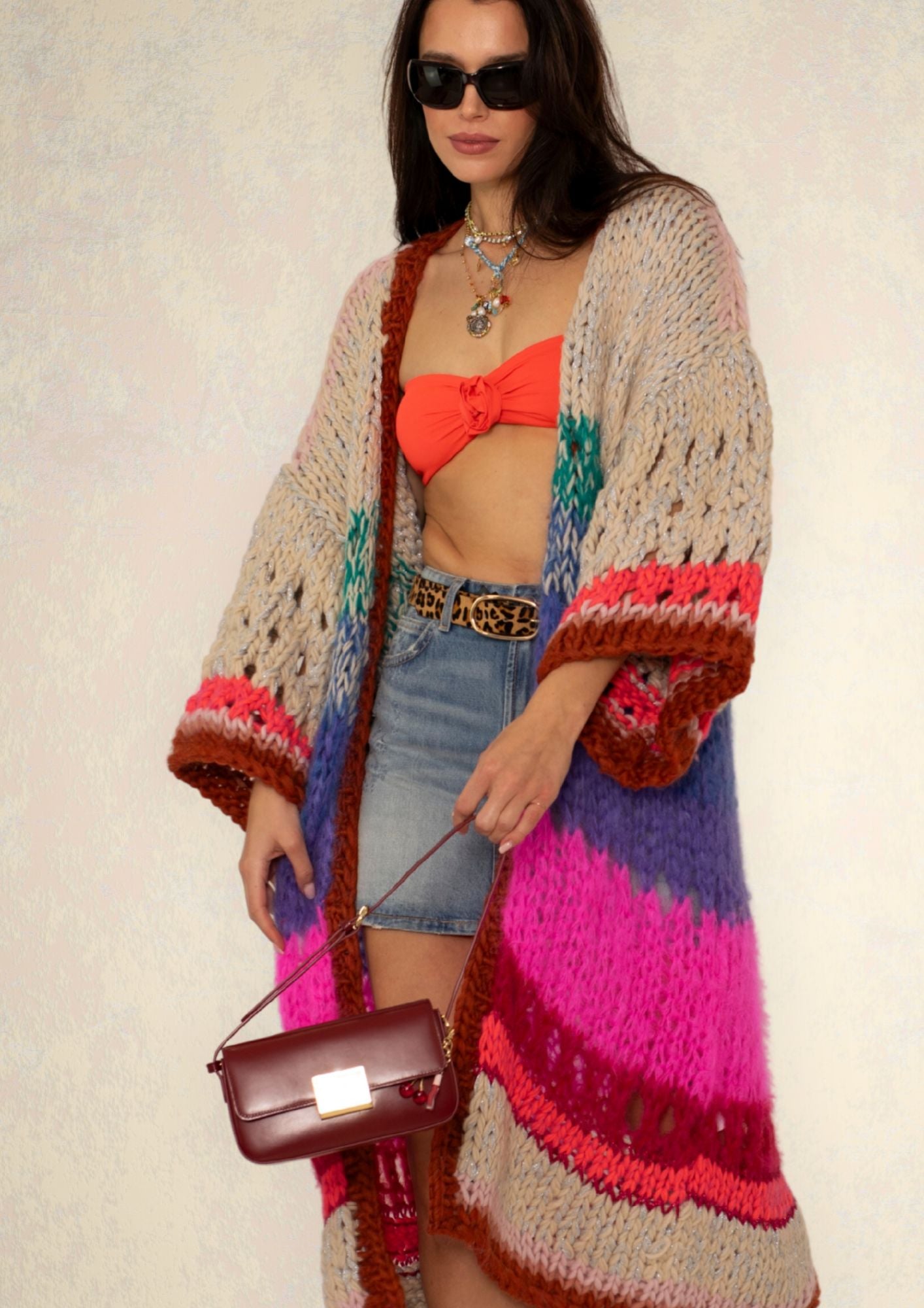 woman with sunglasses wearing a handknitted_luxury_knitted_cardigan and clutch in burgundy