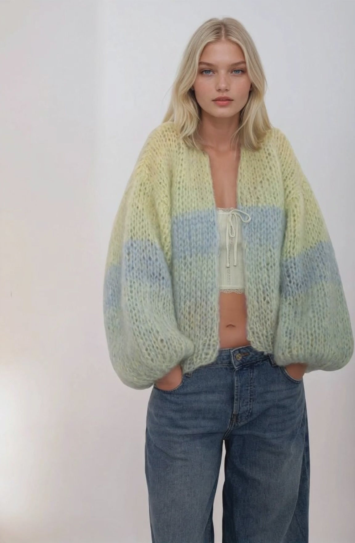 video of a girl in jeans and gradient handknitted sweater in green blue