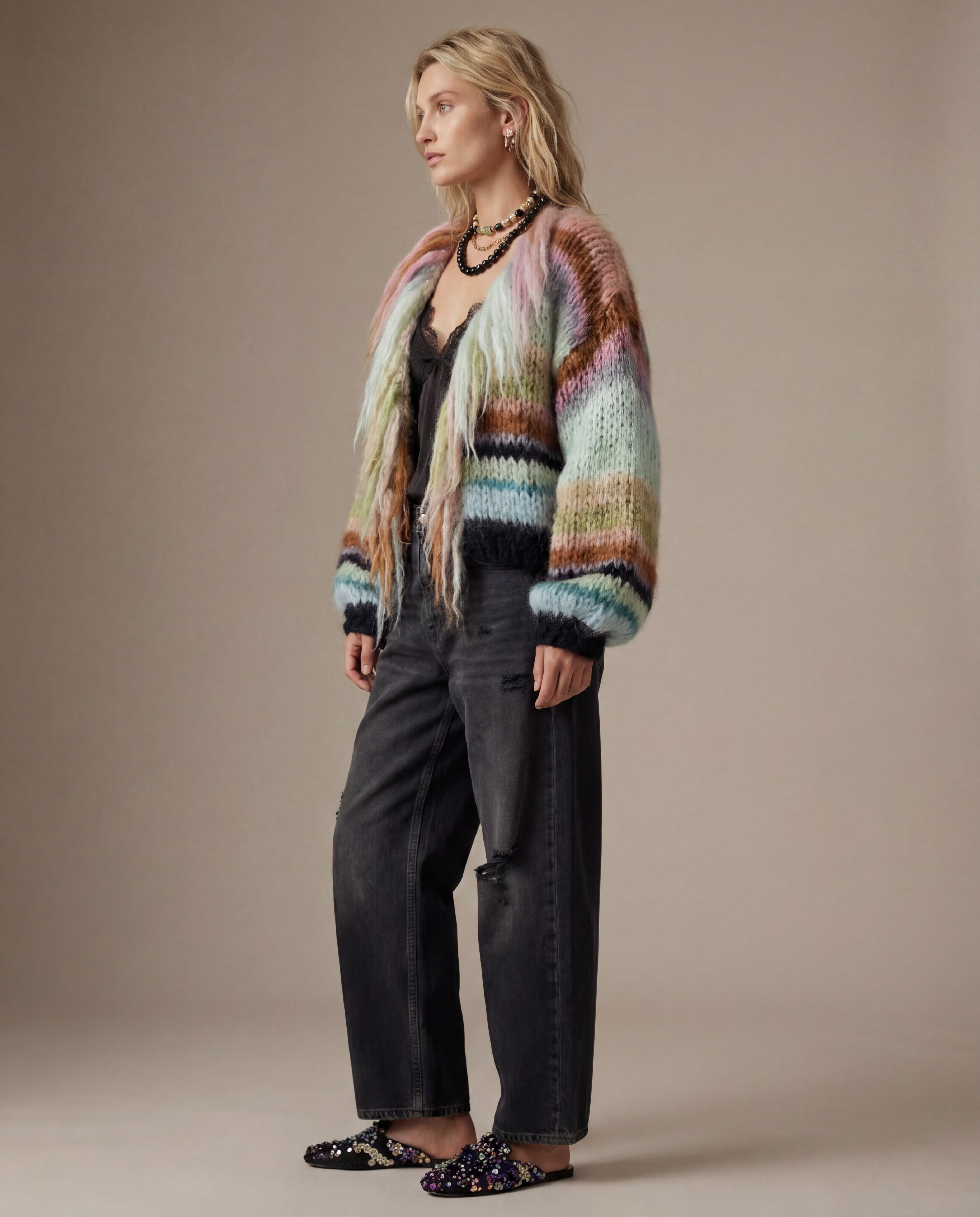 Woman wearing a colorful sweater and black pants against a beige background