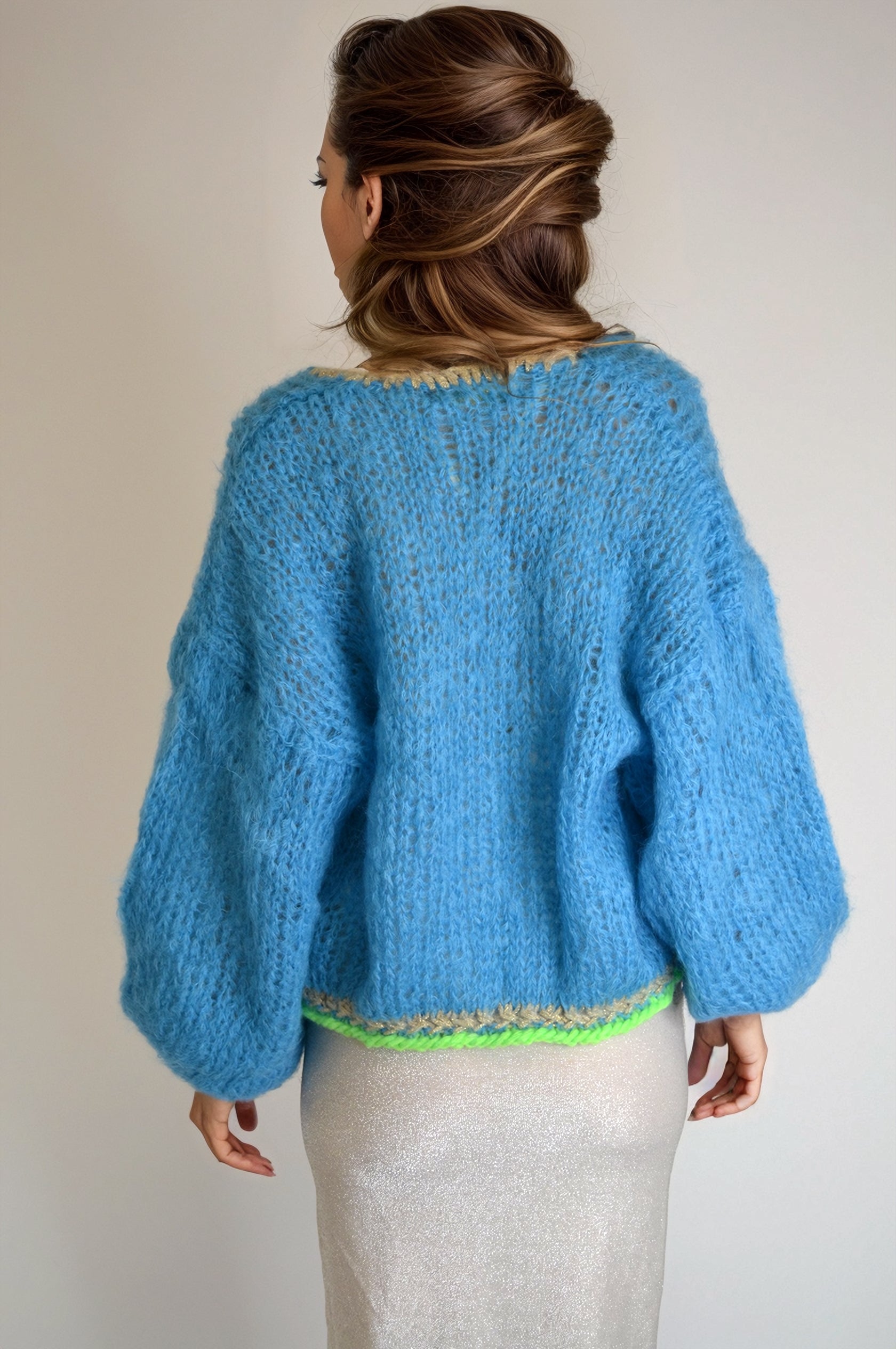 Girl in a lurexdress and a handknitted blue jacket, backview