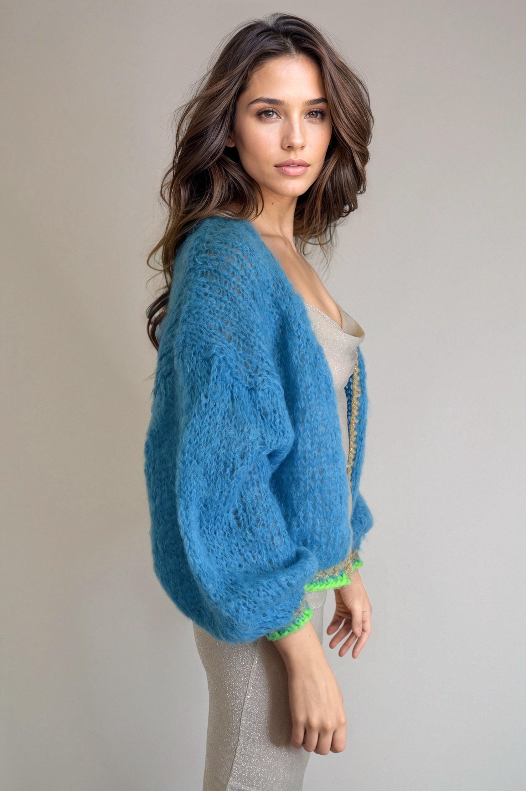 Girl in a lurexdress and a handknitted blue jacket, sideview