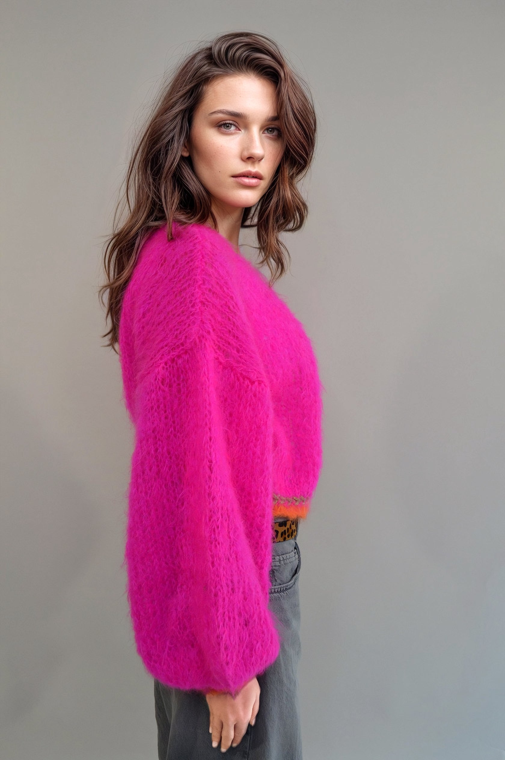 side view of Girl in a jeans and a handknitted hotpink jacket