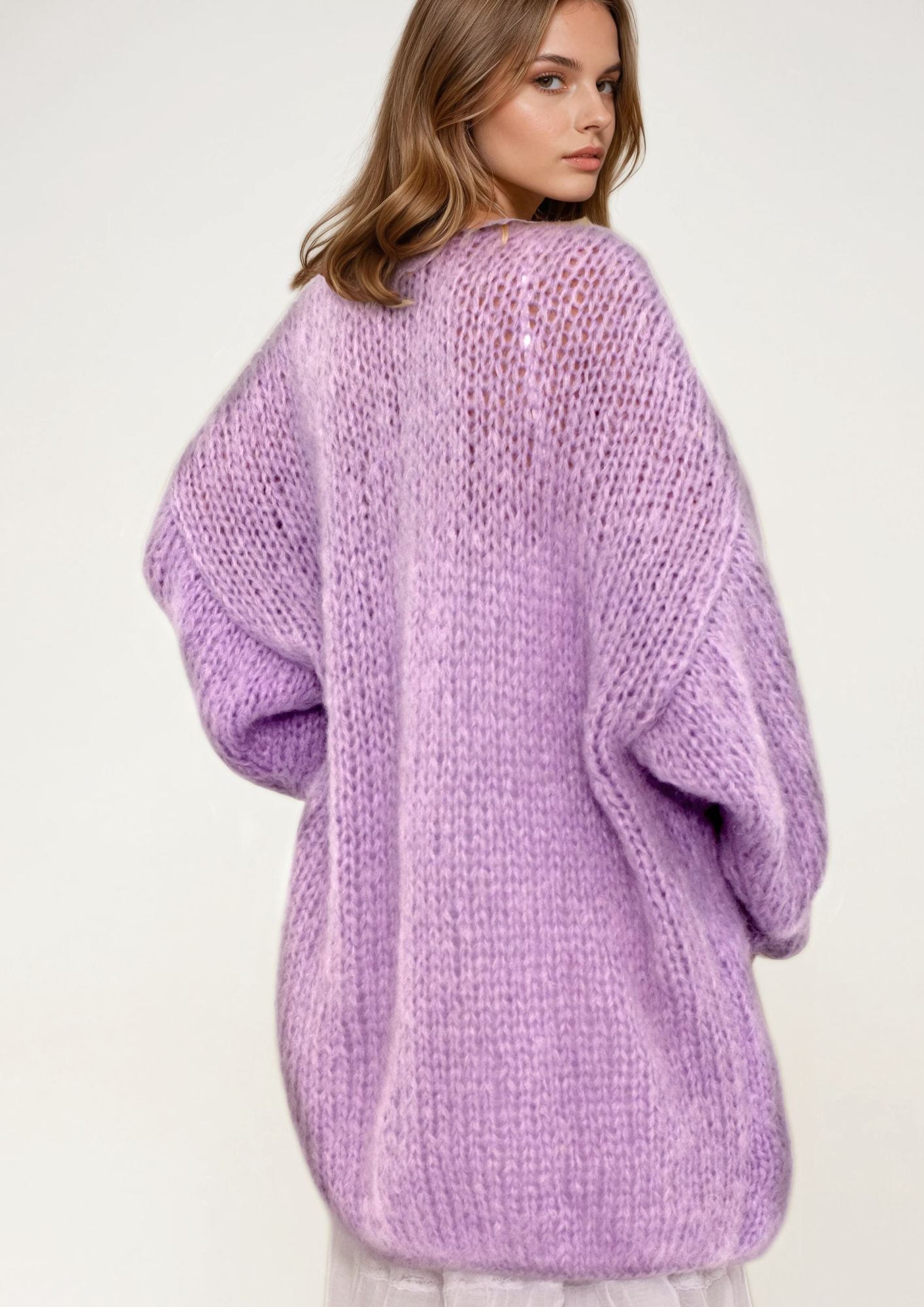 Person wearing a purple oversized sweater on a white background