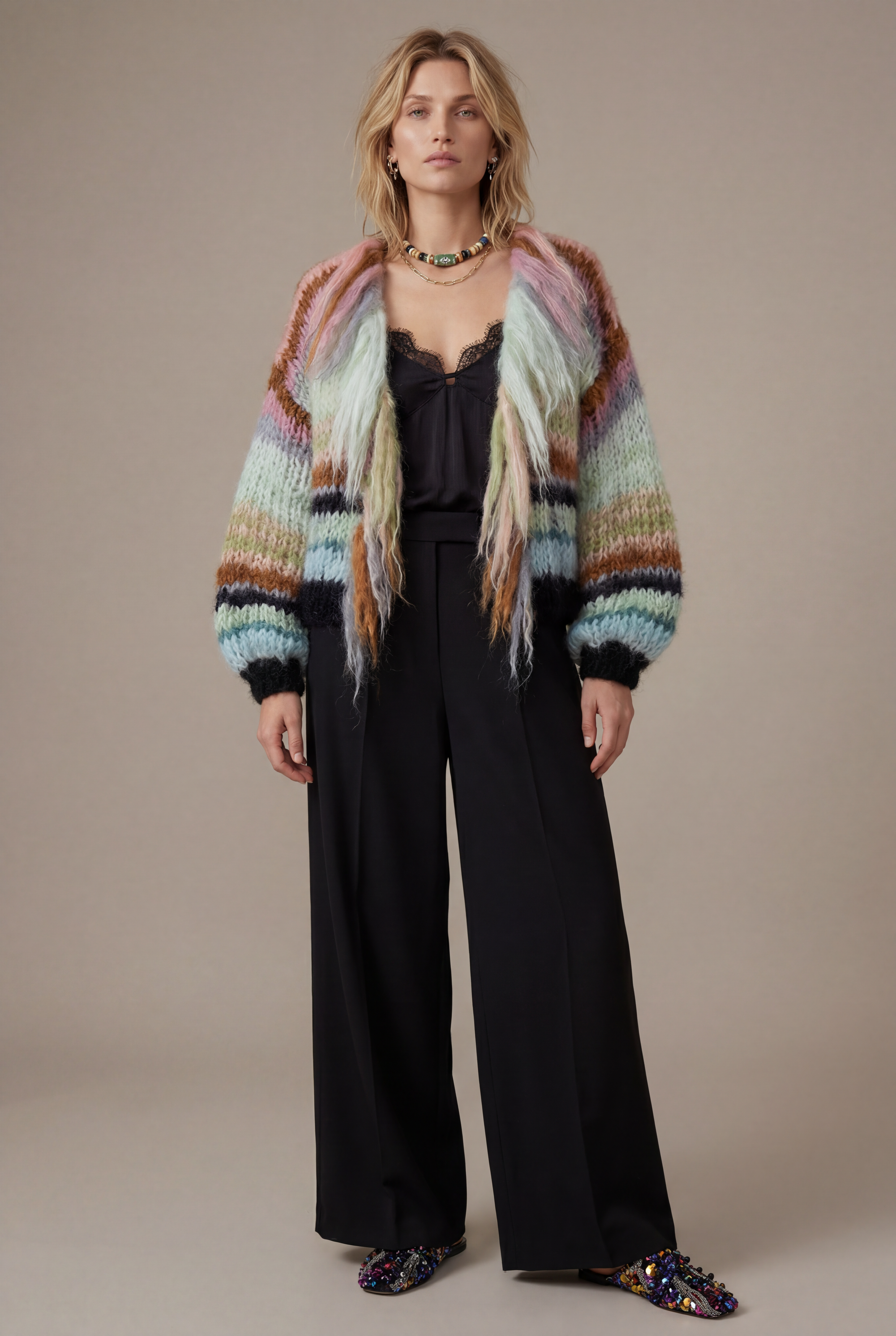 Woman in black trousers, black silk top and mohair striped cardigan with fringes