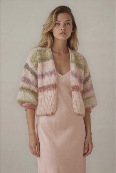 blonde woman in a beige short handknitted cardigan with pastel stripes