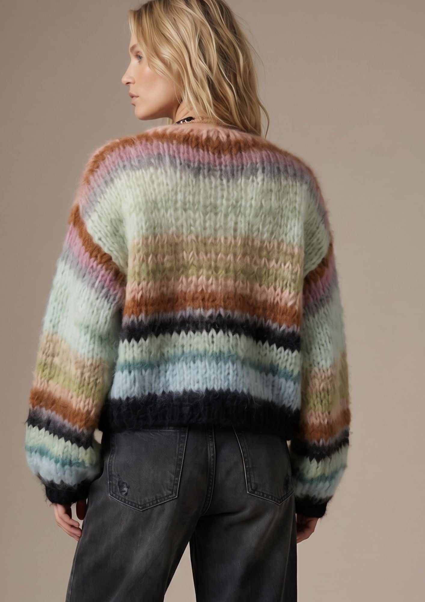 Person wearing a multicolored striped sweater against a beige background